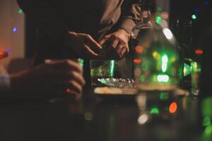 fête nuit, verser whisky dans une verre. donner à copains qui viens à célébrer photo