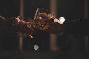 fête nuit, verser whisky dans une verre. donner à copains qui viens à célébrer photo