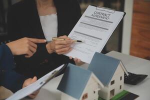 affaires signature une Contrat acheter - vendre loger, Assurance agent en cours d'analyse à propos Accueil investissement prêt réel biens concept. photo