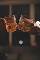 fête nuit, verser whisky dans une verre. donner à copains qui viens à célébrer photo