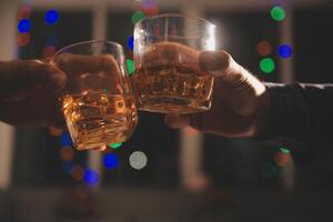 fête nuit, verser whisky dans une verre. donner à copains qui viens à célébrer photo