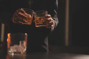 fête nuit, verser whisky dans une verre. donner à copains qui viens à célébrer photo