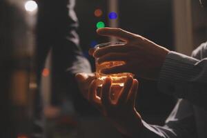 fête nuit, verser whisky dans une verre. donner à copains qui viens à célébrer photo