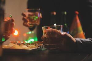 fête nuit, verser whisky dans une verre. donner à copains qui viens à célébrer photo