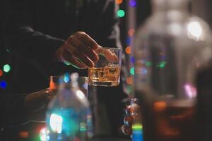 fête nuit, verser whisky dans une verre. donner à copains qui viens à célébrer photo