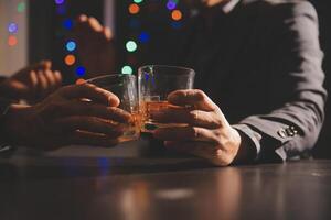 fête nuit, verser whisky dans une verre. donner à copains qui viens à célébrer photo