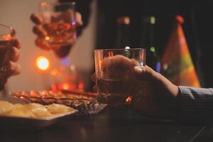 fête nuit, verser whisky dans une verre. donner à copains qui viens à célébrer photo