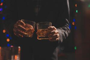 fête nuit, verser whisky dans une verre. donner à copains qui viens à célébrer photo