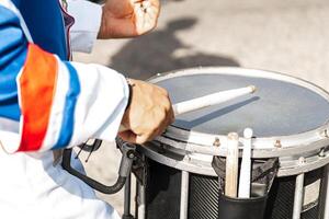 mains de une la personne en jouant une tambour avec pilons. photo