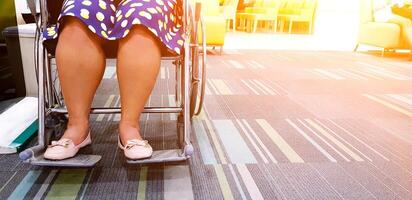 proche en haut femme asseoir sur roue chaise dans hôpital et attendre à voir médecin avec Orange lumière du soleil et copie espace. soins de santé, médical et patient concept photo