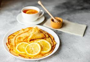 savoureuses belles crêpes à la banane et au miel sur fond de béton photo