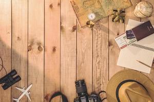 vue aérienne des accessoires de voyage essentiels, articles de vacances et différents objets sur fond en bois. fond de concept de voyage photo