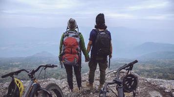 les femmes et les hommes amoureux asiatiques voyagent dans la nature. voyager se détendre faire du vélo dans la nature sauvage. debout sur une falaise rocheuse. Thaïlande photo