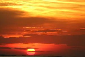 coucher de soleil sur le ciel jaune rouge retour doux soir nuage sur mer horizon photo