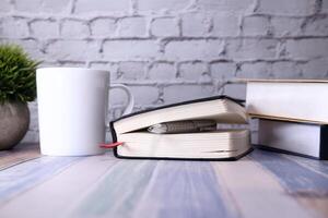 proche en haut de agenda, livre et café agresser sur table photo