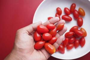 rouge Couleur Cerise tomate sur main photo