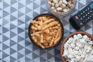 Popcorn, côtelettes dans bol et la télé éloigné sur tableau. photo