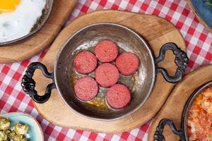 cuisine une plat de petit déjeuner saucisse dans une la poêle sur une en bois table photo