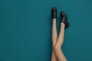 jambes de belle femme dans des chaussures élégantes sur fond de couleur photo