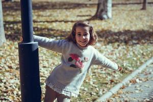 petite fille jouant dans un parc de la ville en automne photo