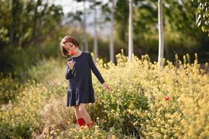 petite fille marchant dans le champ de la nature vêtue d'une belle robe photo