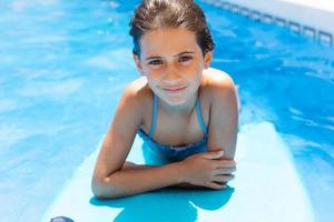 jolie fille jouant avec un bodyboard dans une piscine. photo