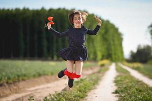 petite fille marchant dans le champ de la nature vêtue d'une belle robe photo