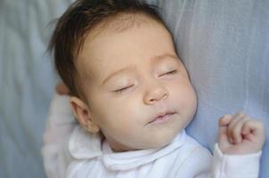 petite fille nouveau-née dormant sur des draps bleus photo