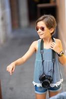 Petite fille faisant une photo avec un appareil photo reflex numérique sur la rue de la ville