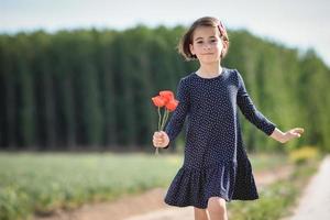 petite fille marchant dans le champ de la nature vêtue d'une belle robe photo