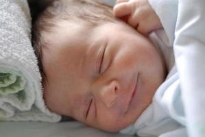 Petite fille nouveau-née dans le lit de l'hôpital dormant photo