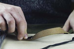 artisan fabrique un bracelet en cuir noir véritable. concept fait main. petite entreprise photo
