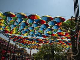 parapluies colorés à l'extérieur comme décor. parapluies de différentes couleurs contre le ciel et le soleil