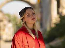 Portrait d'une jeune fille adolescente blonde dans un chapeau noir tricoté dans la rue photo