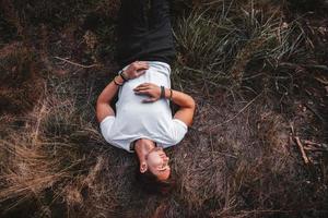 l'homme se trouve sur l'herbe au milieu de la forêt relaxante photo