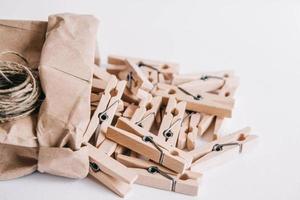 pinces à linge en bois dans un sac en papier avec corde sur fond blanc