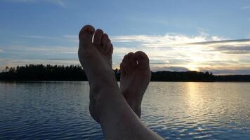 pieds franchi sur le bateau à le coucher du soleil photo