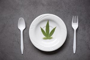 feuille de cannabis - plante de feuilles de marijuana sur assiette blanche et fourchette cuillère, concept d'herbe nature nourriture cannabis photo