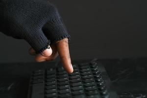 main de pirate volant des données d'un ordinateur portable de haut en bas photo