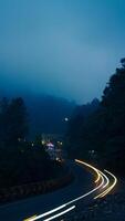 coloré nuit lumière les sentiers sur route avec forêt Contexte dans coup de poing bogor Indonésie photo