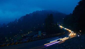 coloré nuit lumière les sentiers sur route avec forêt Contexte dans coup de poing bogor Indonésie photo