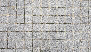 trottoir de pierre. pavés sur les routes et les trottoirs dans la partie ancienne de la ville. fond de matériau de pavage. granit, pavé. modèle de sol de pavé en béton pour le fond. photo