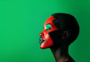 africain américain Jeune femme avec sa visage peau peint dans rouge, noir et vert couleurs. noir histoire copie espace Contexte. photo