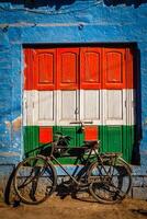 vélo et porte peint dans Inde nationale drapeau couleurs. Jodhpur, Inde photo