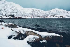 norvégien fjord avec rouge rorbu Maisons dans Norvège dans hiver photo