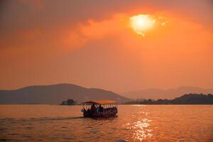 bateau dans Lac pichola sur le coucher du soleil. udaïpur, rajasthan, Inde photo