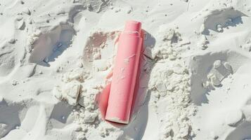 une rose soin de la peau tube mensonge dans blanc sable. photo