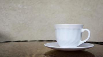 café aromatique chaud avec du lait. une boisson fraîchement préparée est servie dans une tasse moderne sur une table en osier léger. photo