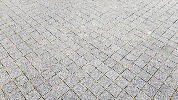 trottoir de pierre. pavés sur les routes et les trottoirs dans la partie ancienne de la ville. fond de matériau de pavage. granit, pavé. modèle de sol de pavé en béton pour le fond. photo