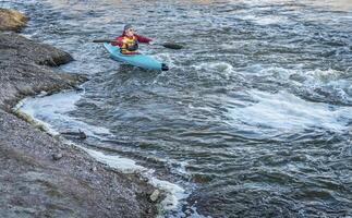 Masculin pagayeur dans une eau vive kayak photo